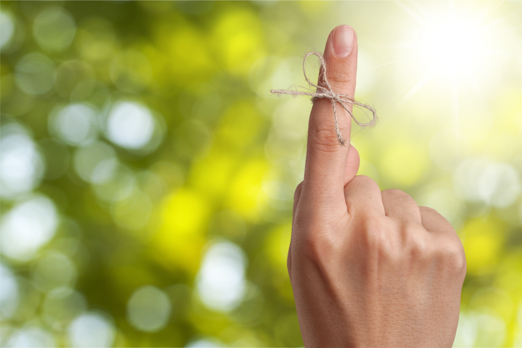Rope bow on finger pointing up on background